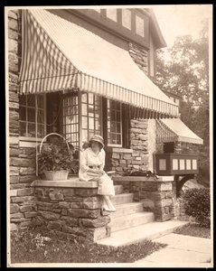 Een vrouw zittend bij de ingang van een huis, 1915 door Byron Company